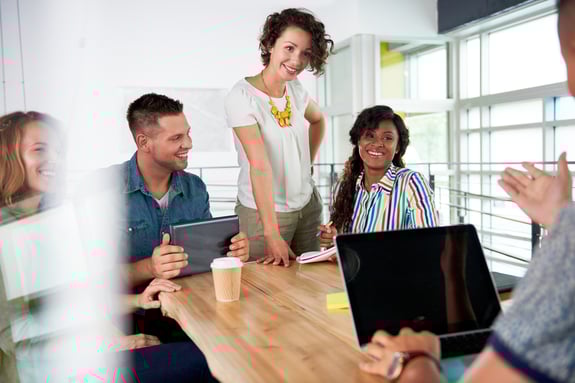 Multi ethnic group of succesful creative business people using a laptop during candid meeting-3